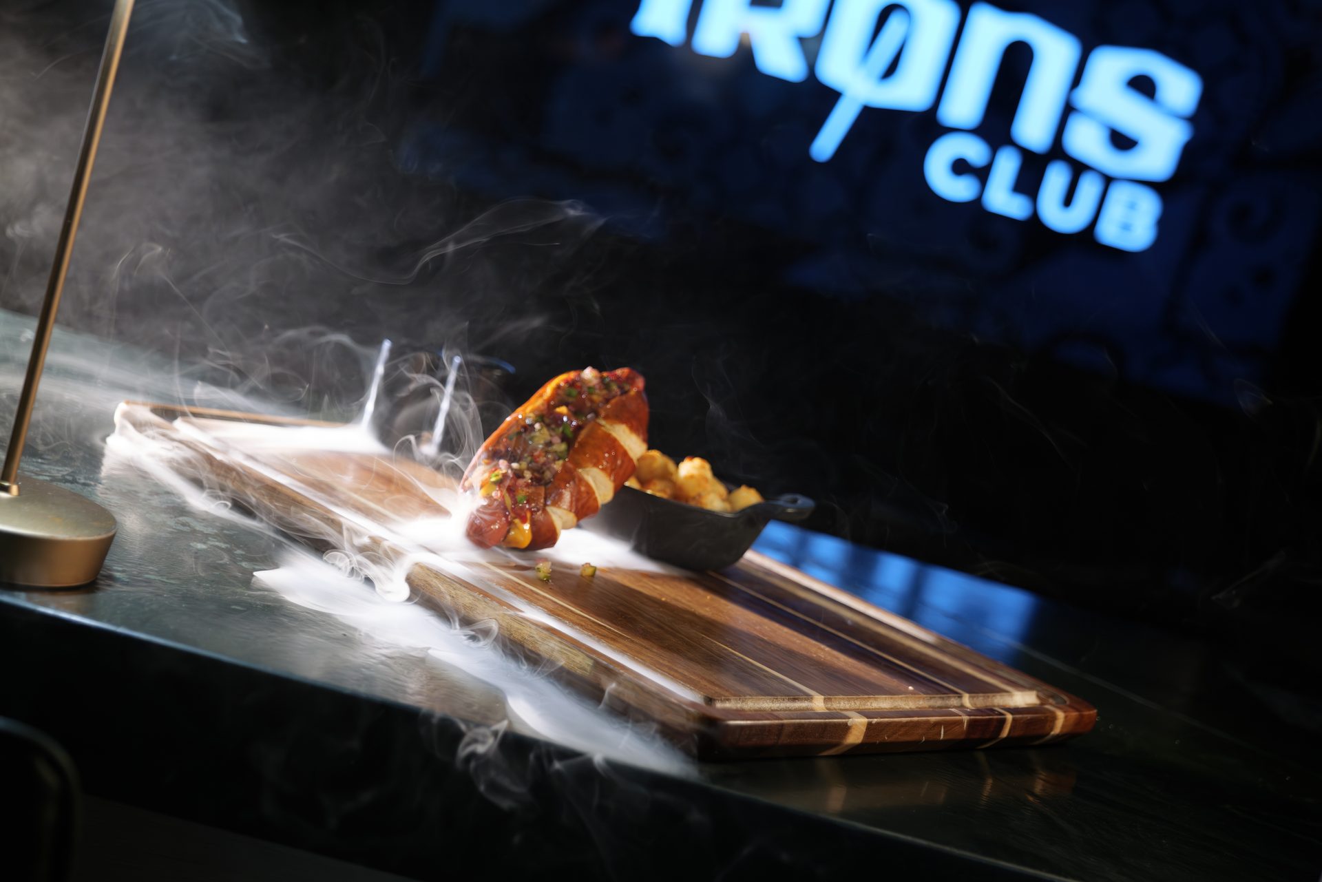 44 Dawg hero shot — gourmet hot dog with smoke at Irons Club